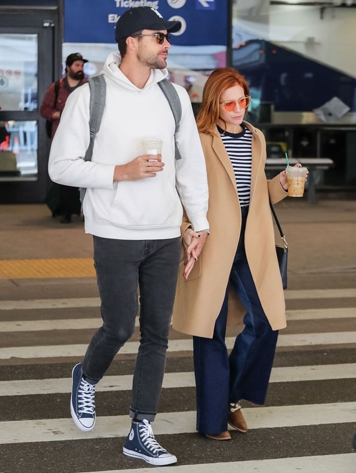 Brittany Snow and Tyler Stanaland hold hands at LAX Airport