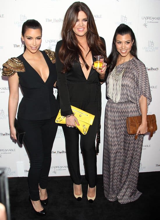 Kourtney Mary Kardashian (R) posing with her two younger sisters, Kim (L) and Khloé (M)