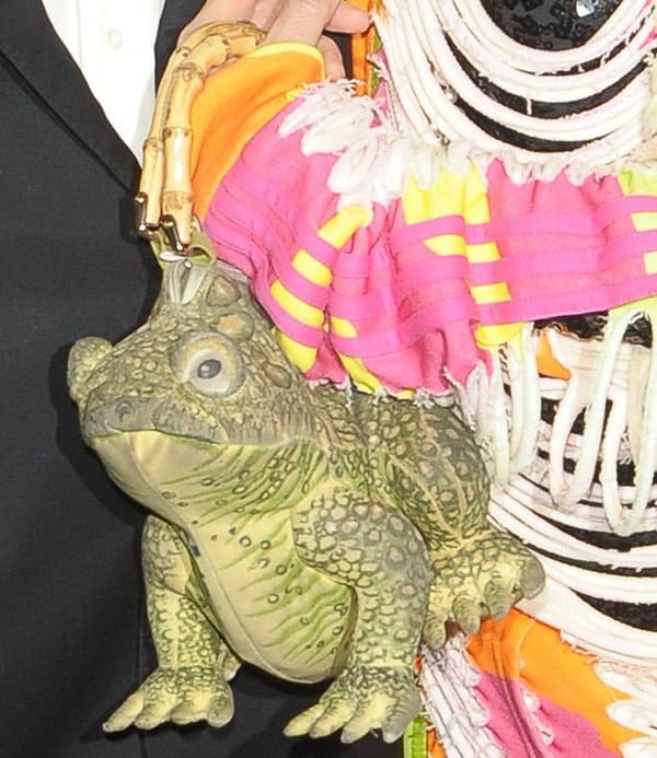 Su Pollard carrying an incredibly ugly frog handbag