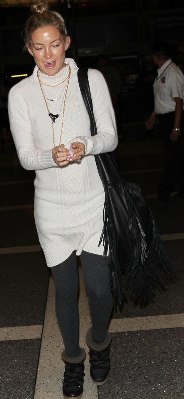 Kate Hudson styled her white cable sweater dress with Isabel Marant Nowles shearling-lined leather concealed wedge boots
