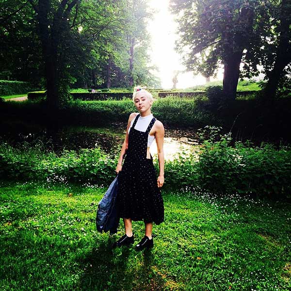 Miley Cyrus wears a Comme des Garçons printed dress with a Topshop skinny polo crop top and platform sneakers