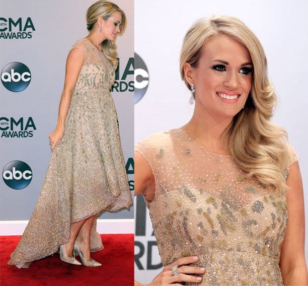 Singer Carrie Underwood in a cream-colored Lorena Sarbu dress featuring embroidery, a high-low hem, a sweetheart neckline, and a sheer overlay at the 48th annual CMA Awards