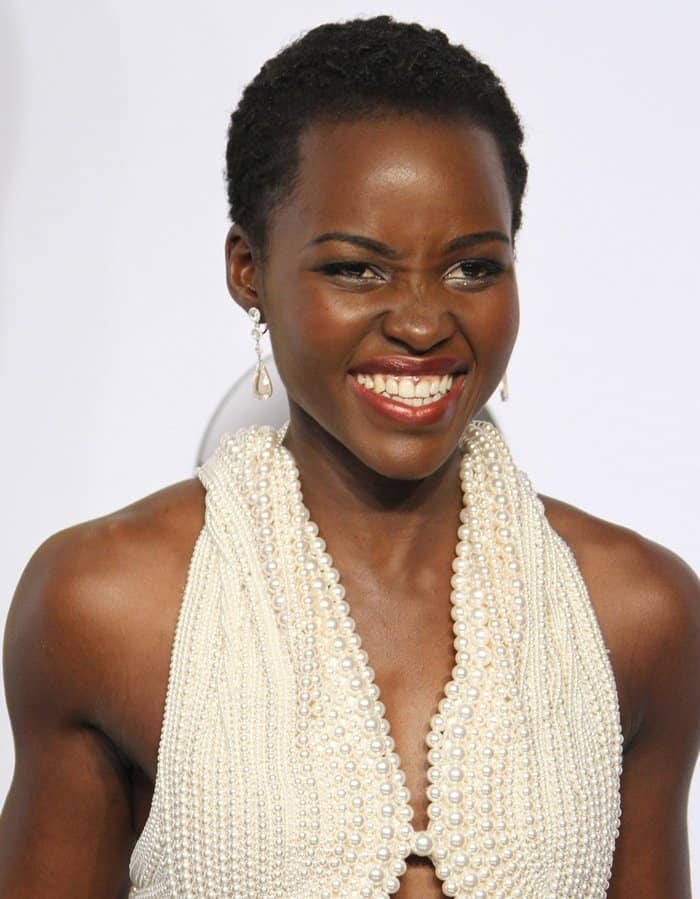 Lupita Nyong'o in a stunning ivory Calvin Klein Collection halter dress adorned with 6,000 pearls and diamond drop earrings
