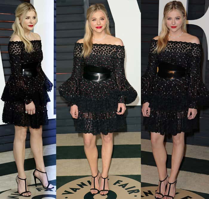 Chloe Grace Moretz attended the Vanity Fair Party wearing an Alexander McQueen Pre-Fall 2015 black lace dress with mini flowers, a tiered skirt, bell accent sleeves, and a black leather waist belt