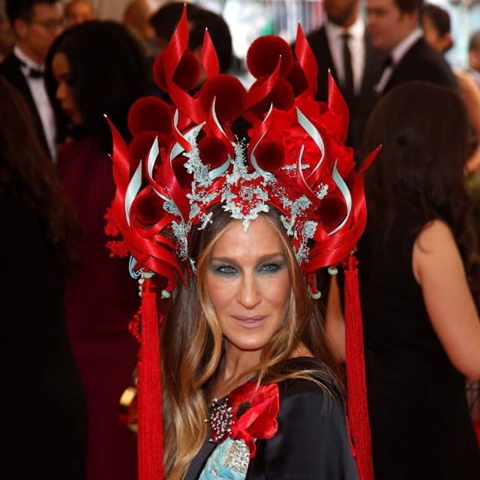 Sarah Jessica Parker wore a wild Philip Treacy headpiece with long tassels, ribbony flames, and furry, red pom-poms