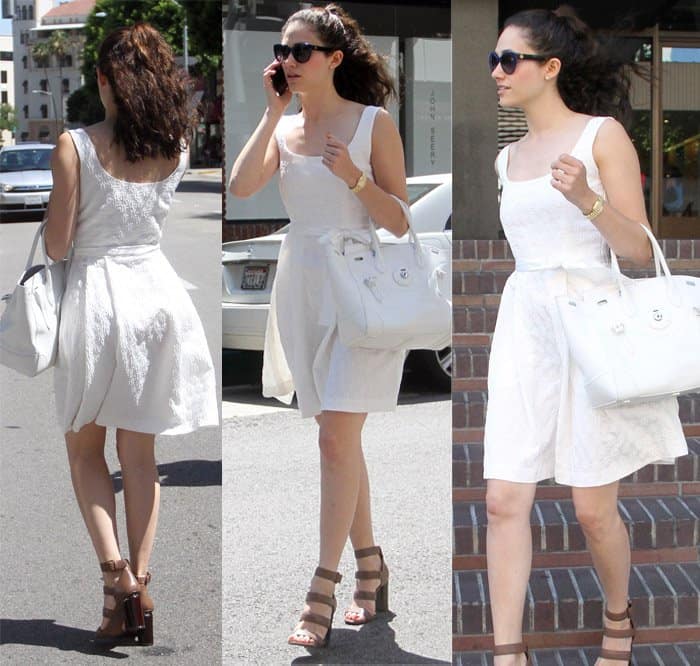 Emmy Rossum, dressed in a white summer dress with a white oversized handbag and strappy brown heels, goes shopping in Beverly Hills