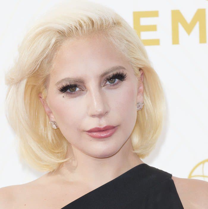 Lady Gaga's platinum blonde bob and naturally beautiful makeup, with a metallic smoky eye, completed her strikingly minimalistic appearance - a departure from her usual flamboyant style