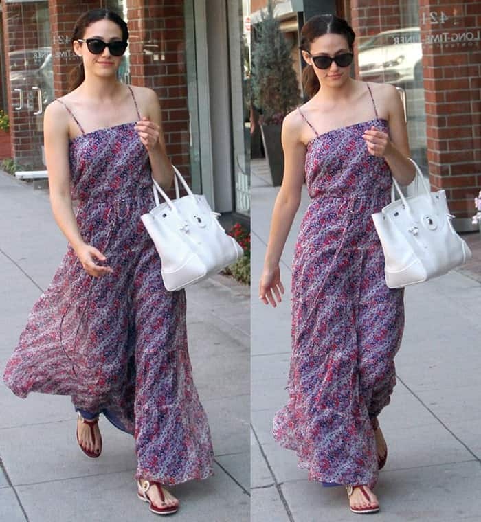 Emmy Rossum in a breezy summer outfit featuring a floral maxi dress and brown sandals