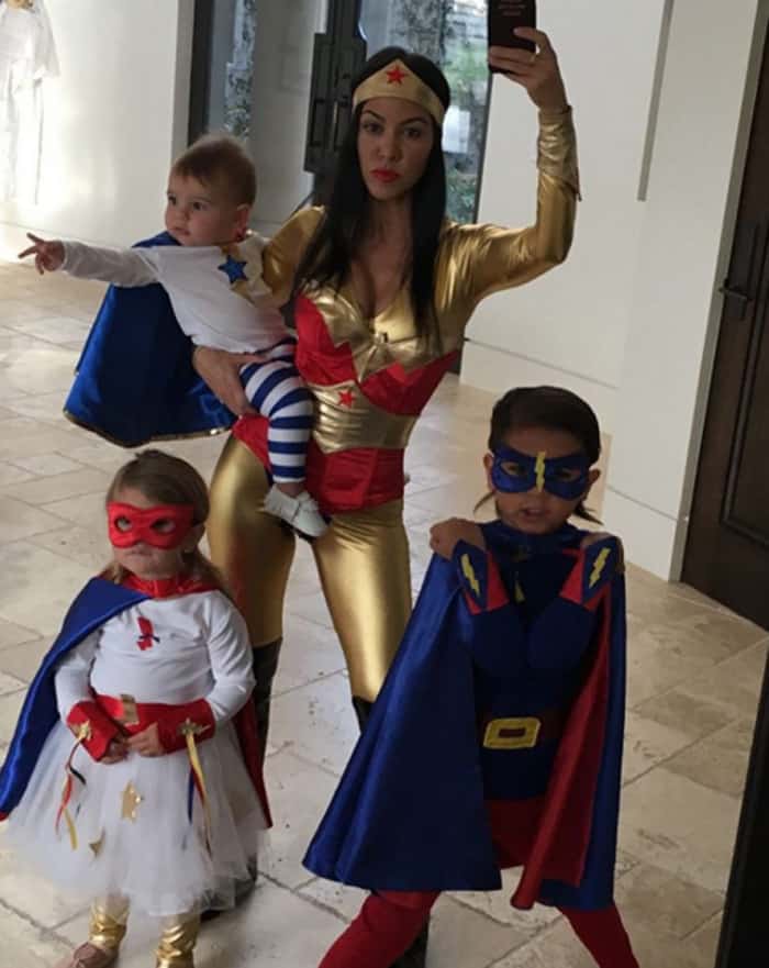 Kourtney Kardashian embodied Wonder Woman, donning a red and gold all-in-one costume paired with knee-high black boots, perfectly capturing the iconic superhero's look