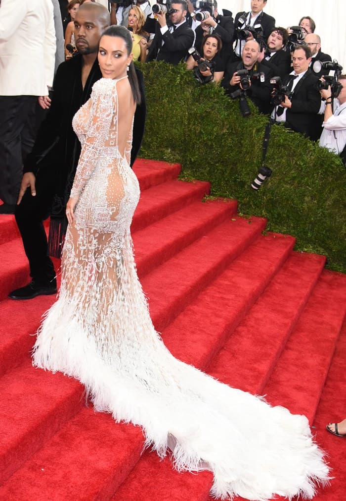 Kim Kardashian's dress exuded drama with its body-con allure and intricate lacy beading that flowed into a long train of wispy feathers