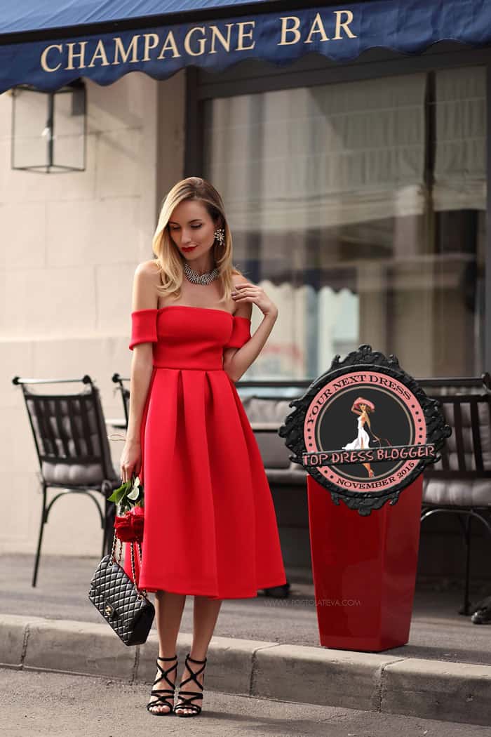 Silvia is flirty but elegant in an off-the-shoulder red dress with strappy black sandals