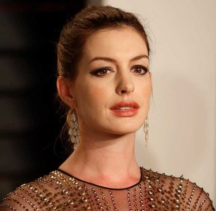Anne Hathaway accessorized with Irene Neuwirth earrings and a braided ponytail hairstyle