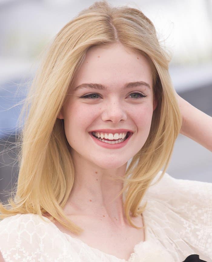 Elle Fanning radiated impeccable style in an enchanting white lace gown at a photo call for “Neon Demon”