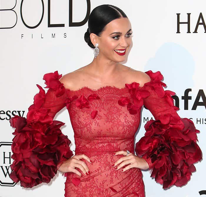 Katy Perry's sleek pulled-back bun and perfectly matching red lip enhanced the overall look, showcasing a harmonious blend of style elements