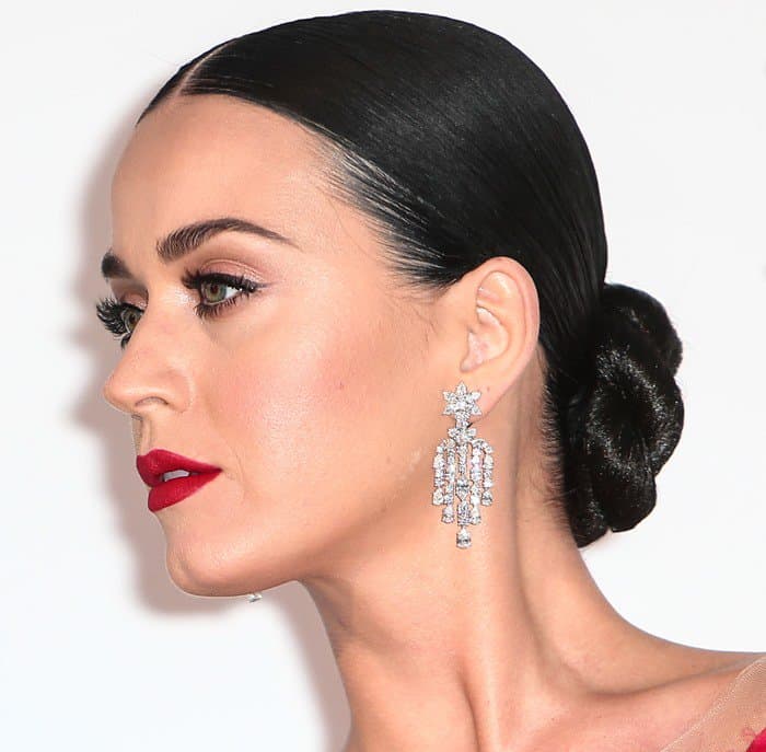 Enhancing her allure, Katy Perry sported a smoldering red lip that perfectly matched her meticulously sculpted cat-eye makeup, collectively forming a look that was both mesmerizing and unforgettable