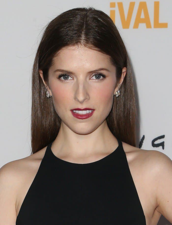 Anna Kendrick complemented her ensemble with straight, off-the-shoulder tresses that framed her face with a touch of timeless allure, and a bold red lip added a splash of vibrant color