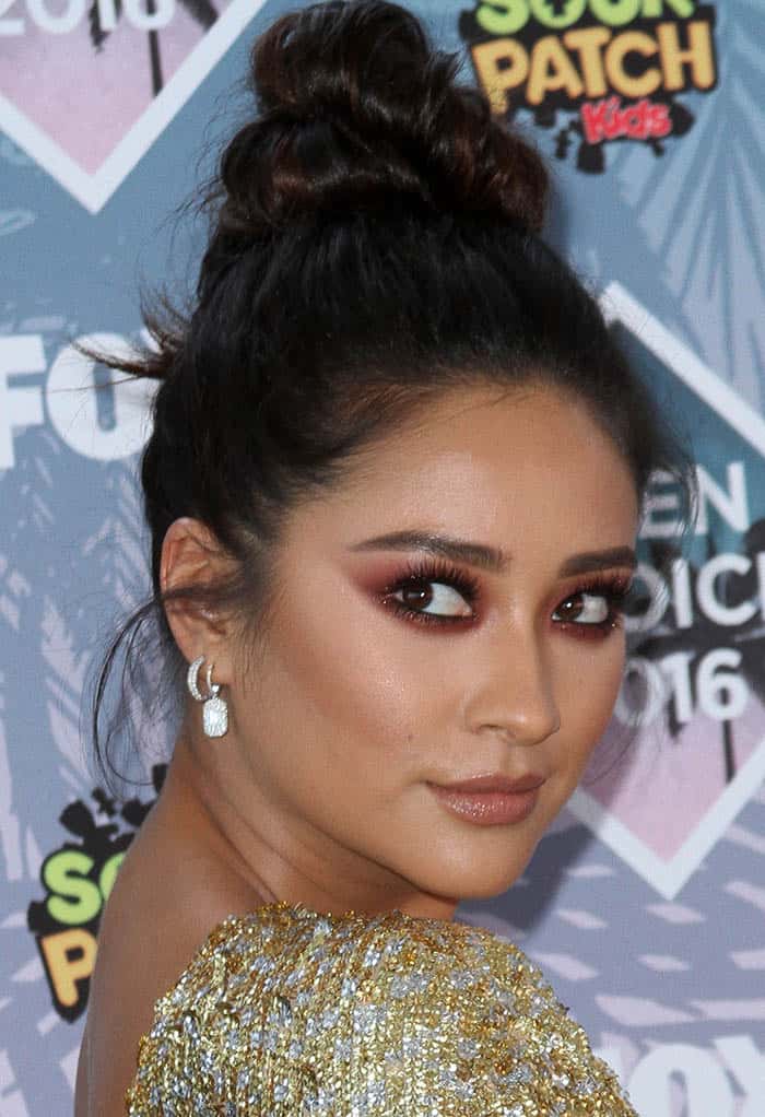 Shay Mitchell's sultry burgundy eye makeup added a touch of allure to her look, while a twisted top knot showcased her impeccable taste at the Teen Choice Awards 2016
