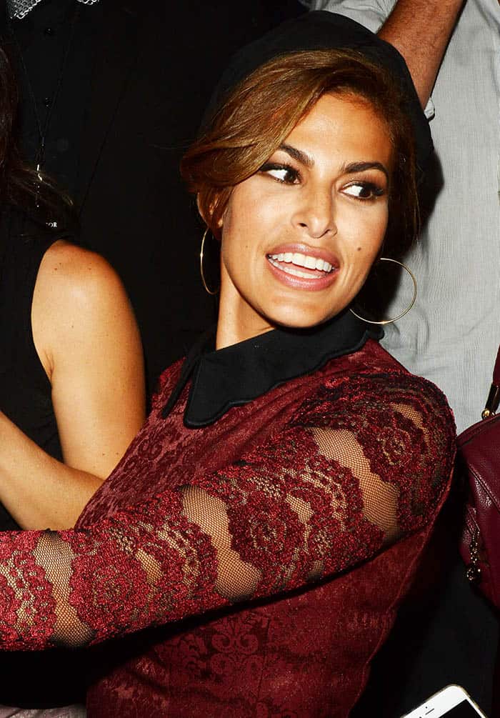 Eva Mendes wore a red mini dress from her own collection, which featured long sleeves, a short A-line skirt, and a scalloped black collar
