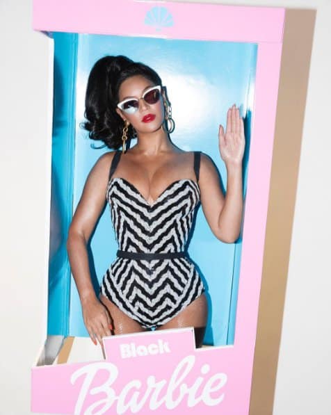 Beyonce dressed as classic black Barbie in a black-and-white striped swimsuit paired with cat-eye sunglasses