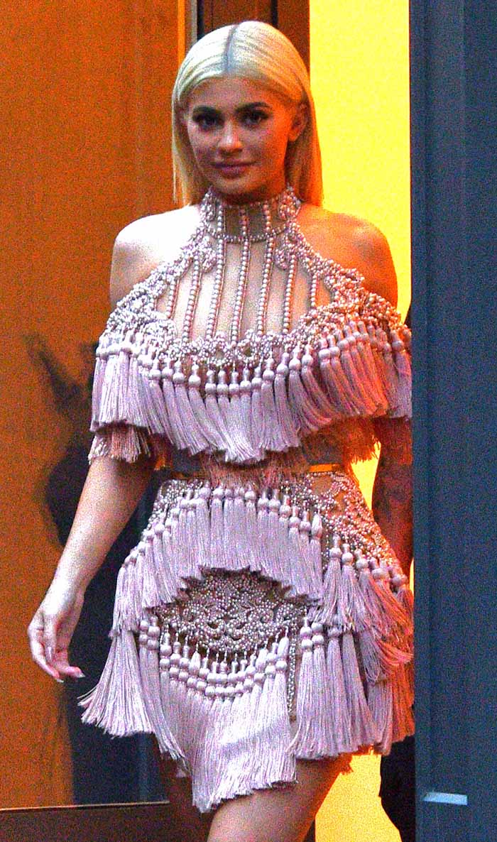 Kylie Jenner's high-necked, off-the-shoulder dress was a fusion of elements, boasting sheer panels, pearl beading, and abundant tassels