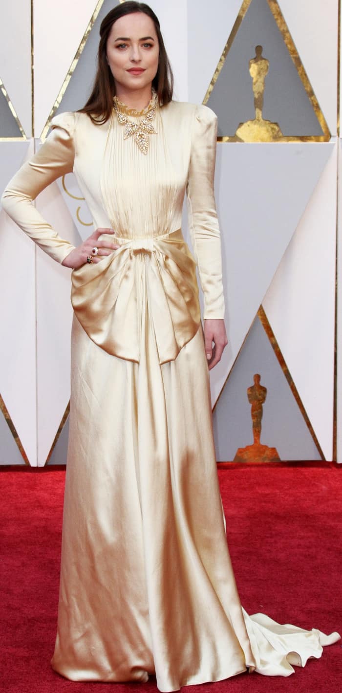 Dakota Johnson wearing a gold Gucci fall 2017 satin gown at the 2017 Oscars