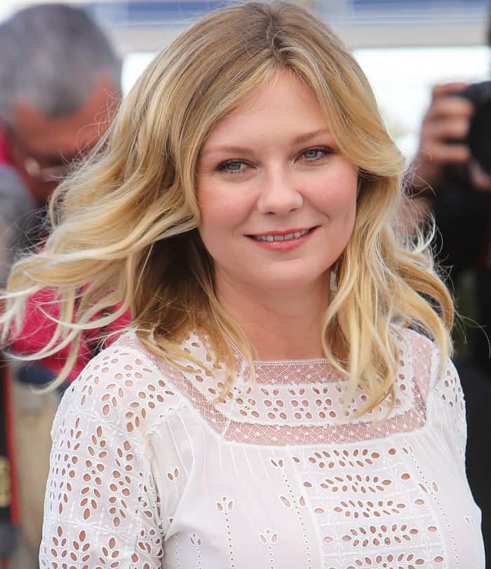 Kirsten Dunst wearing a white Loewe spring 2017 dress and Gucci ankle-strap sandals at "The Beguiled" photocall during the 70th annual Cannes Film Festival