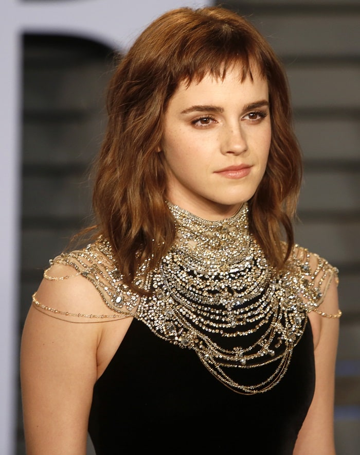 Emma Watson wearing a black column gown featuring an embellished neckline