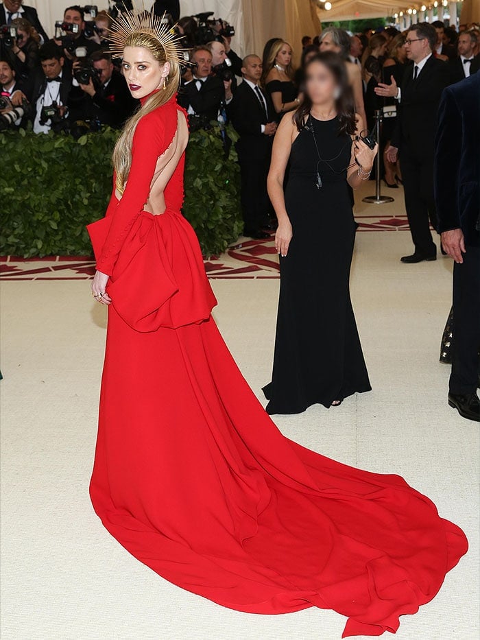 Back view of Amber Heard's Carolina Herrera red long-sleeved open-back gown.