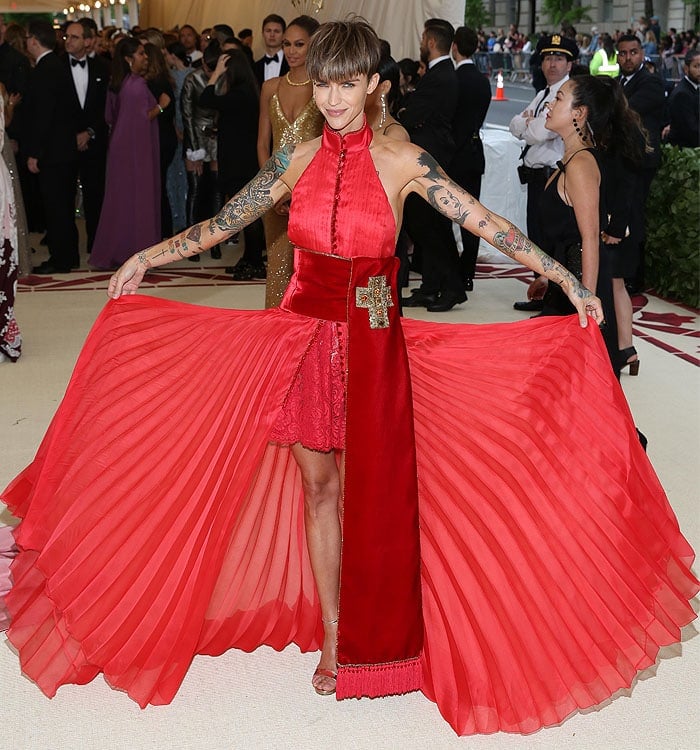 Ruby Rose in a Tommy Hilfiger red pleated dress with a velvet sash and gold Jimmy Choo 'Kaylee' sandals.